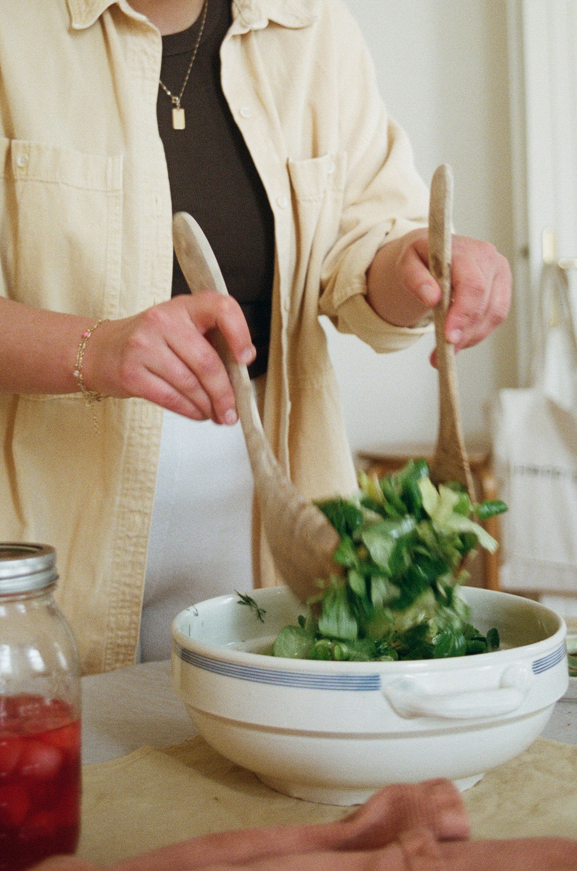 Frau vermischt Salat in Schüssel